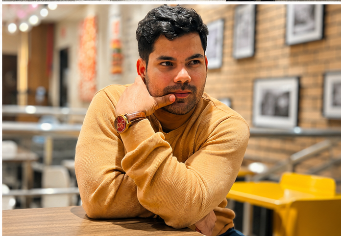 Juned Siddiqui sitting at a café table, reflecting on business strategy and entrepreneurship in a professional setting.